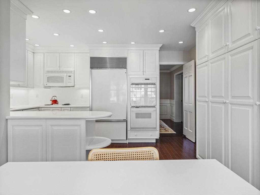 14 Colgate Road Wellesley, MA 02482 - Photo 4 of 19 a kitchen with white cabinets and refrigerator