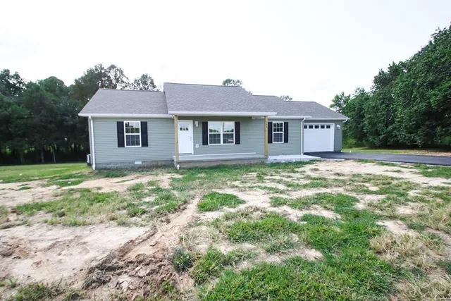 a view of a house with yard and a tree
