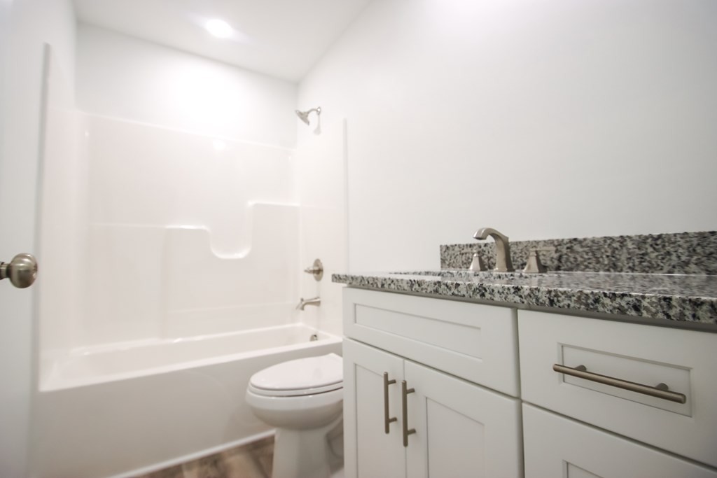 156 Will Thompson Road Sparta, TN 38583 - Photo 15 of 20 a bathroom with a granite countertop toilet a sink and bathtub