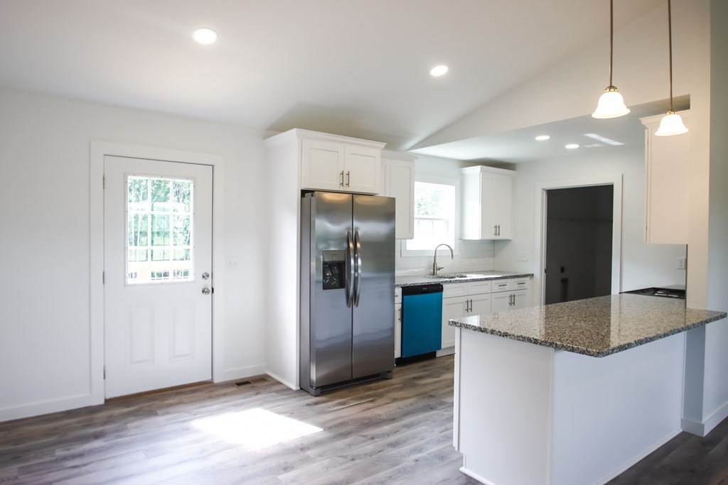 156 Will Thompson Road Sparta, TN 38583 - Photo 6 of 20 a kitchen with stainless steel appliances granite countertop a refrigerator a sink a stove a microwave and island with wooden floor