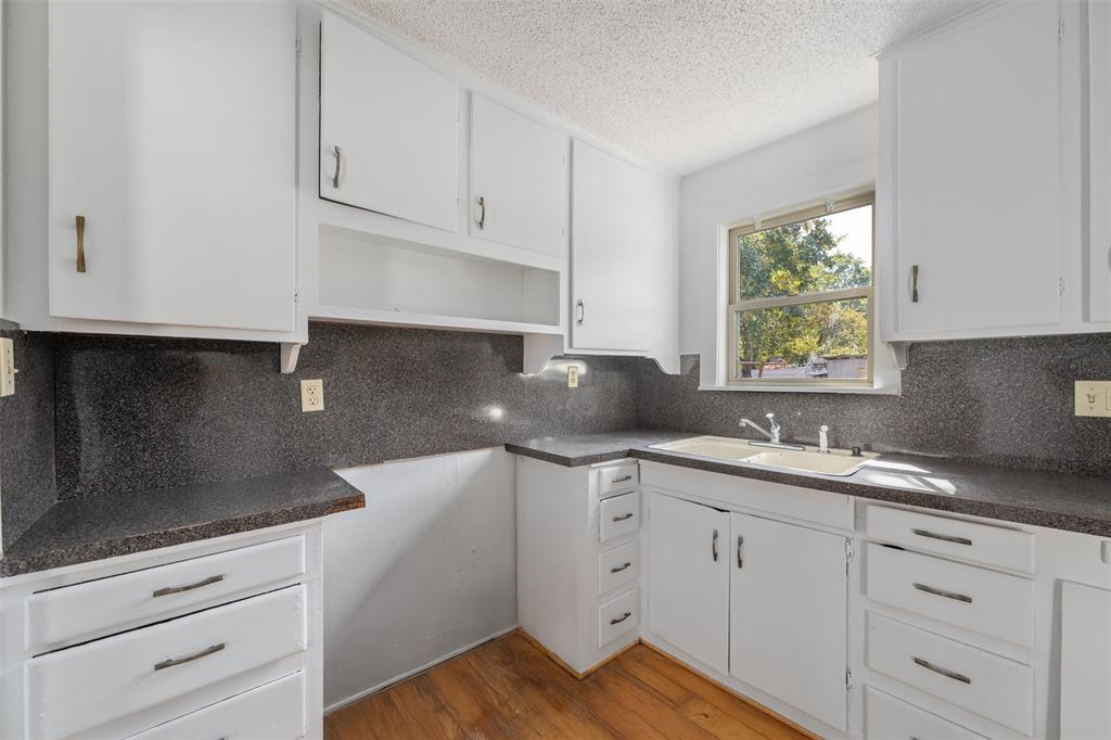102 San Saba Avenue Benbrook, TX 76126 - Photo 8 of 25 a kitchen with white cabinets and a sink