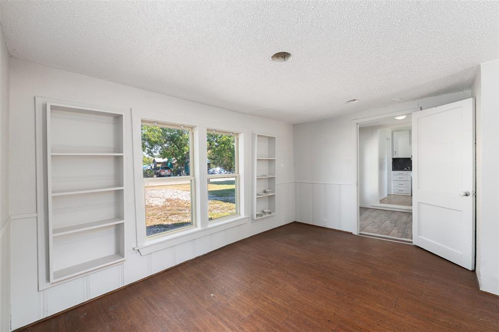 102 San Saba Avenue Benbrook, TX 76126 - Photo 10 of 25 a view of an empty room with a window and wooden floor