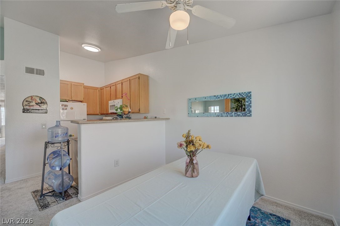 3318 North Decatur Boulevard, Unit 2072 Las Vegas, NV 89130 - Photo 17 of 50 A well-lit dining area features a convenient breakfast bar adjacent to the kitchen, perfect for casual meals.