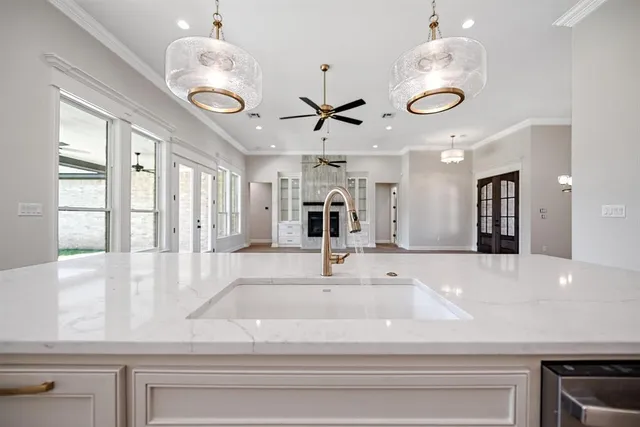 a kitchen with a refrigerator chandelier and white cabinets
