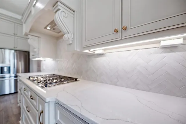 a large kitchen with stainless steel appliances kitchen island granite countertop a stove and a large kitchen countertops with wooden floor