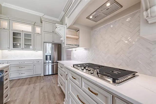 a kitchen with granite countertop a sink cabinets and stainless steel appliances