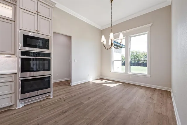 a large kitchen with kitchen island granite countertop wooden floor stainless steel appliances and a fireplace