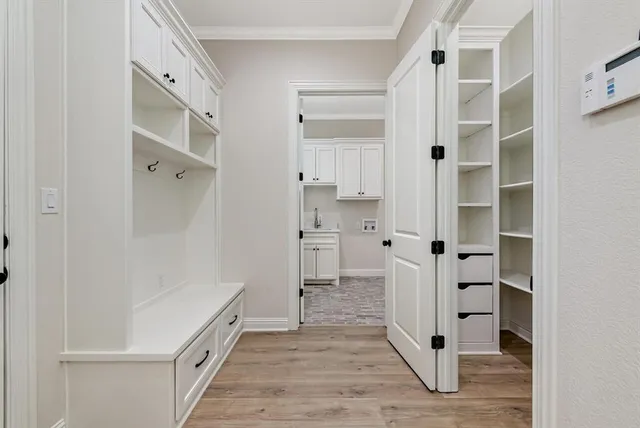 a view of an empty room with a kitchen and wooden floor