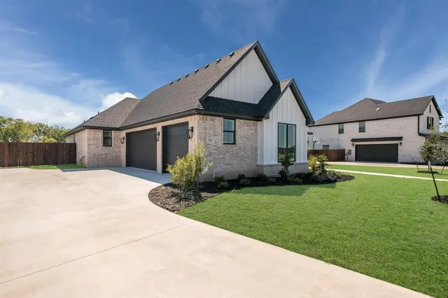 a front view of a house with a garden and yard