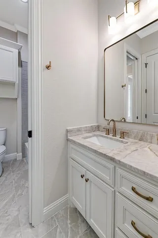 a bathroom with a granite countertop sink mirror toilet and bathtub
