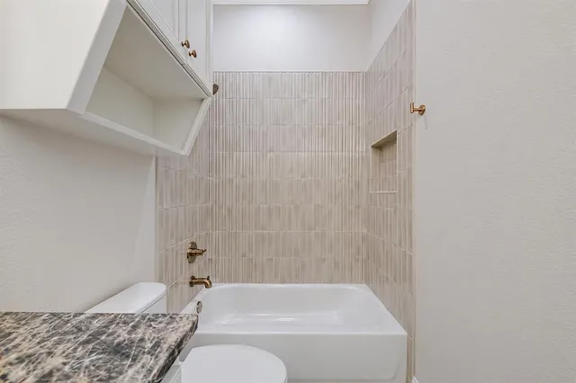 a view of a livingroom with a ceiling fan & windows