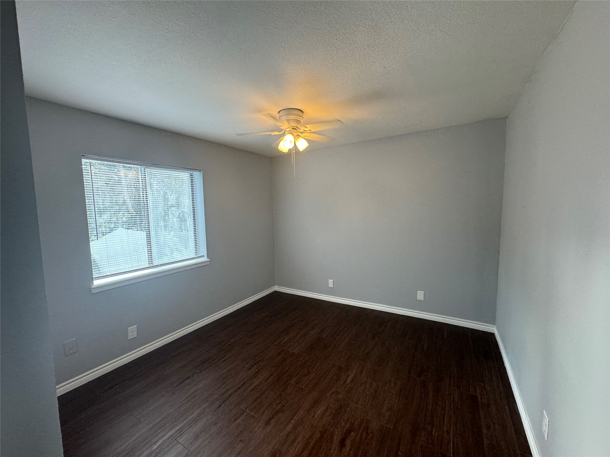 1221 Houston Street, Unit 1 Rosenberg, TX 77471 - Photo 4 of 11 wooden floor in an empty room with a window