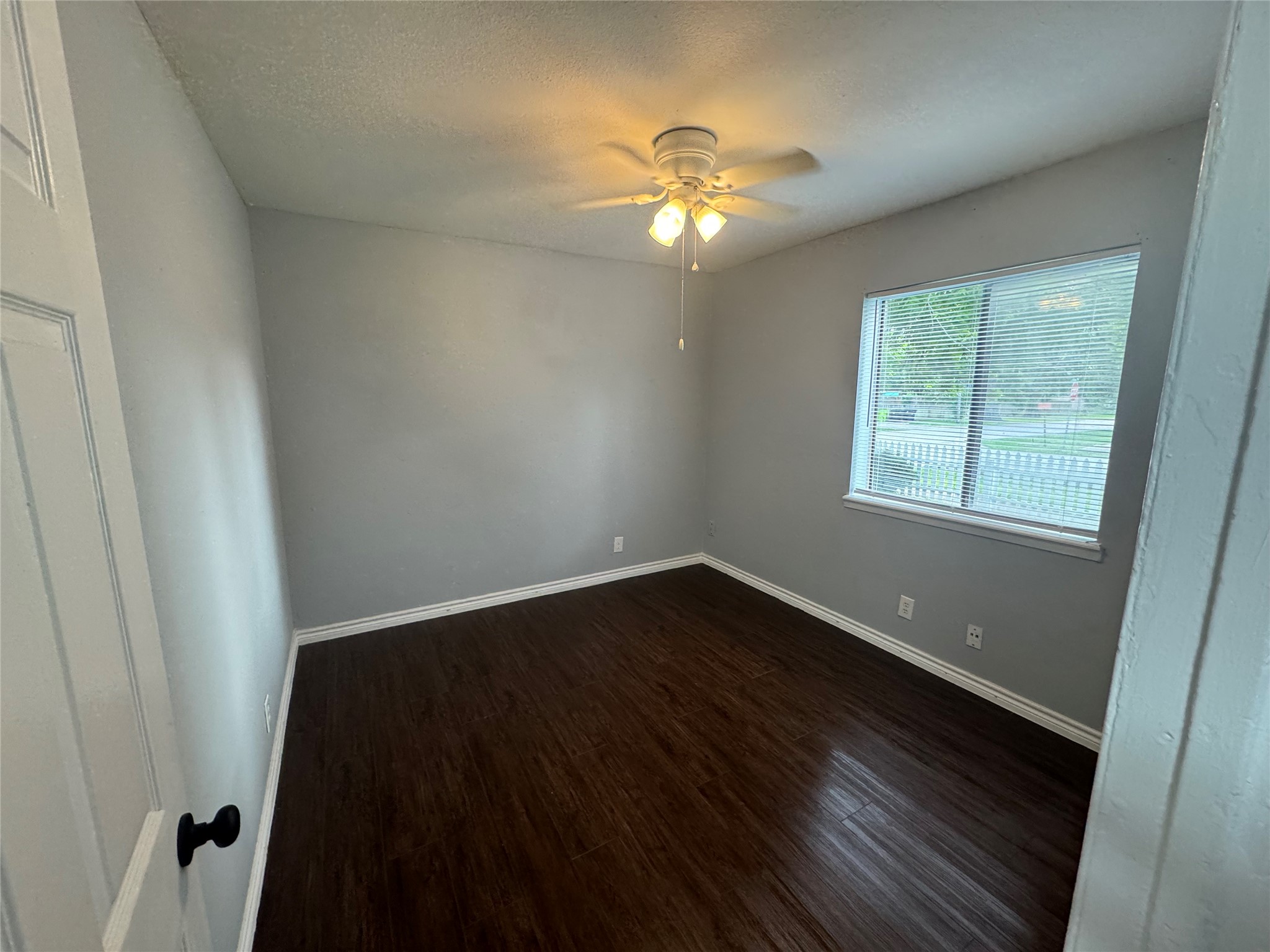 1221 Houston Street, Unit 1 Rosenberg, TX 77471 - Photo 6 of 11 a view of an empty room with wooden floor and a window