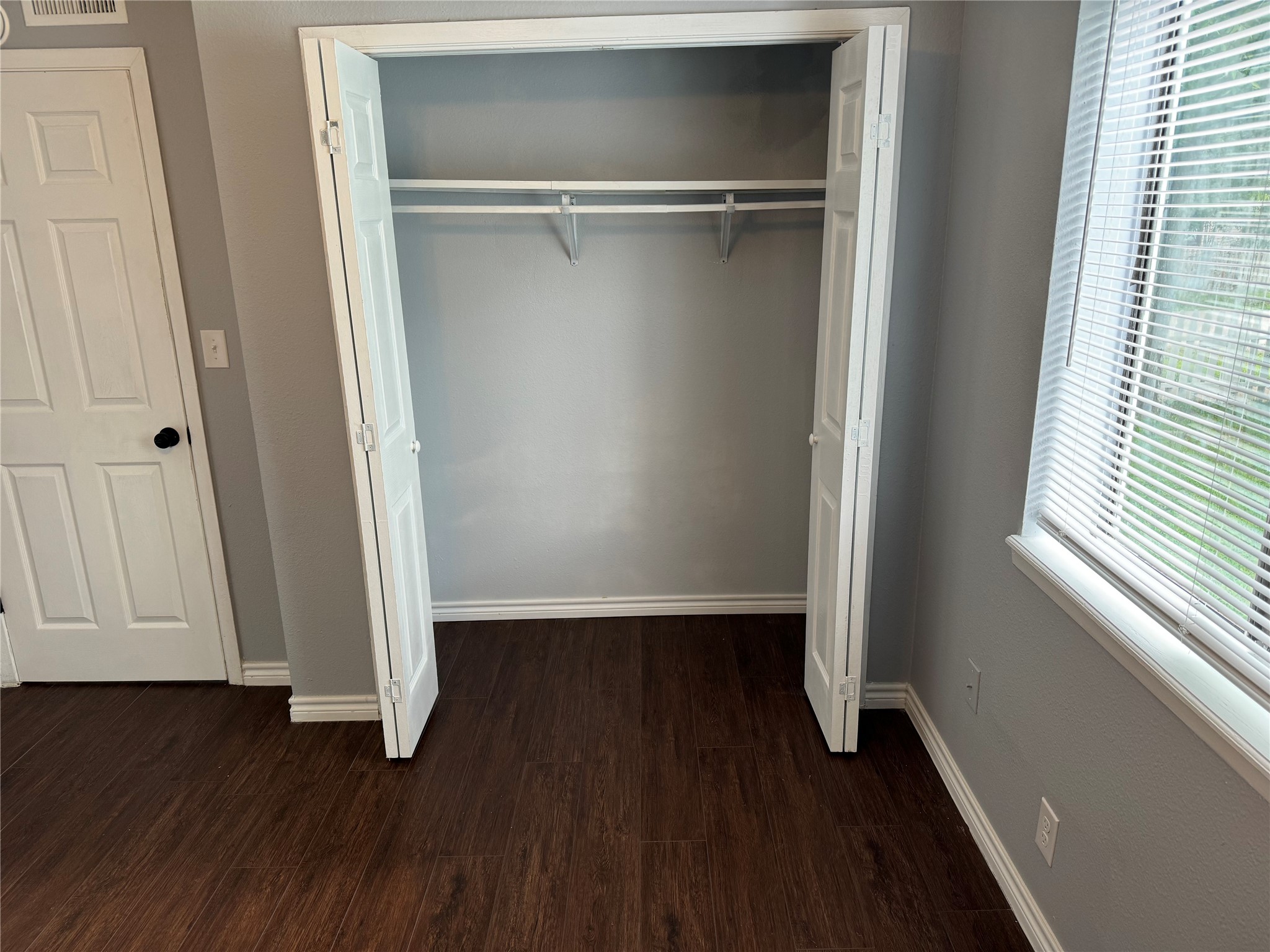 1221 Houston Street, Unit 1 Rosenberg, TX 77471 - Photo 7 of 11 a view of an empty room with wooden floor and a window