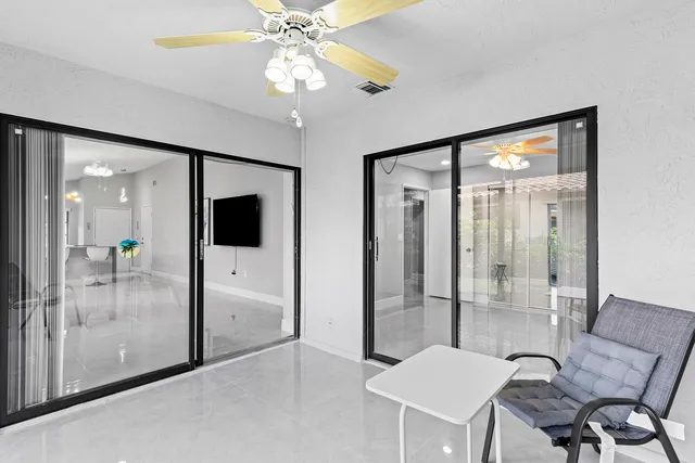 a view of a room with furniture and a chandelier fan