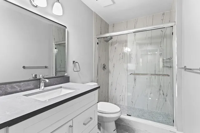 a bathroom with a sink a toilet and shower