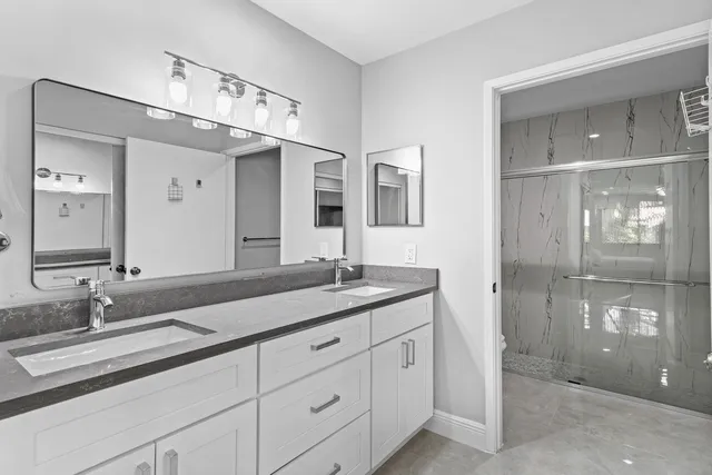 a bathroom with double vanity sinks and a mirror