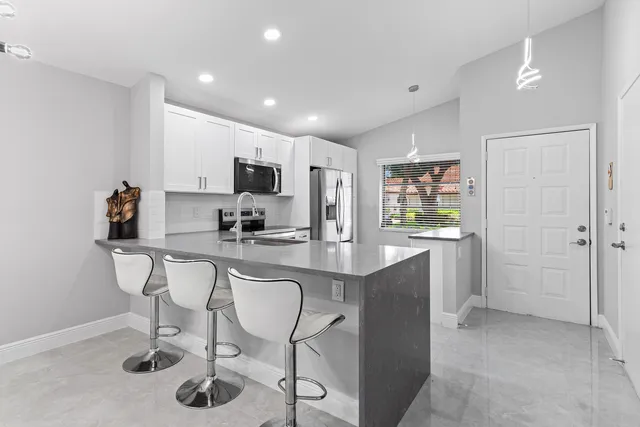 a kitchen with stainless steel appliances granite countertop a sink and a refrigerator