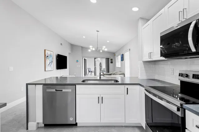 a kitchen with white cabinets stainless steel appliances and sink