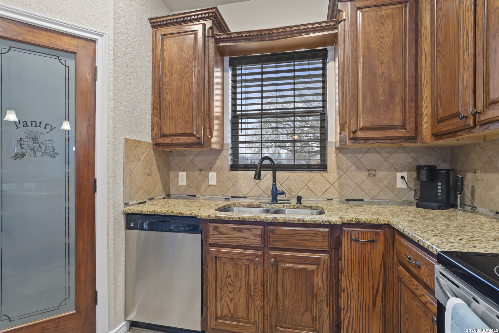 500 Wagon Train Road La Vernia, TX 78121 - Photo 13 of 44 a kitchen with stainless steel appliances granite countertop a sink and cabinets