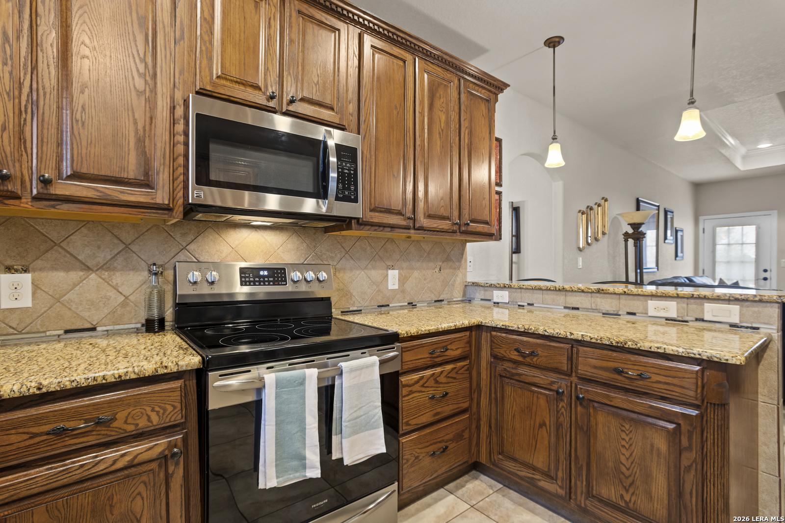 500 Wagon Train Road La Vernia, TX 78121 - Photo 14 of 44 a kitchen with stainless steel appliances granite countertop a stove a sink and a microwave