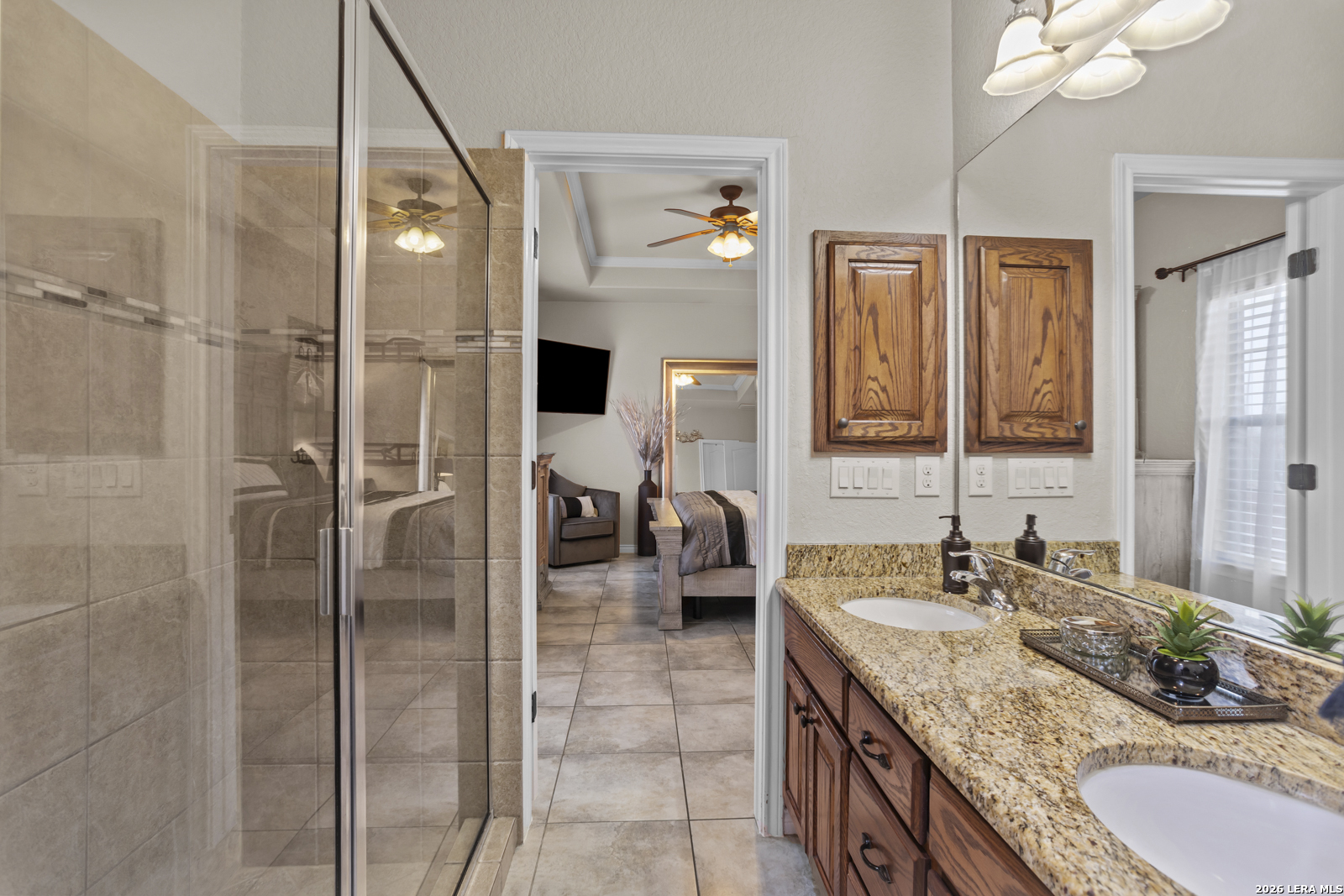 500 Wagon Train Road La Vernia, TX 78121 - Photo 22 of 44 a en suite bathroom with a granite countertop double vanity sink a mirror and a shower