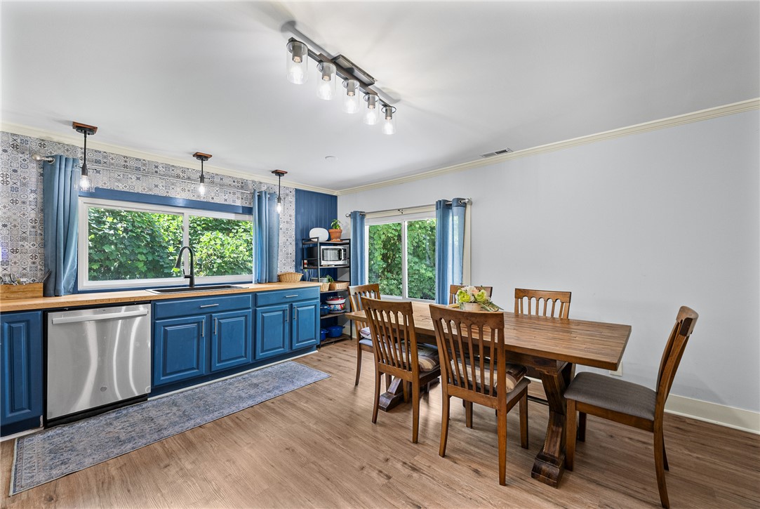 203 Muller Road Walhalla, SC 29691 - Photo 8 of 34 Gleaming LVP floors and classic crown molding anchor this open-concept dining area and kitchen.