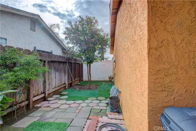 a view of a backyard with plants and wooden fence
