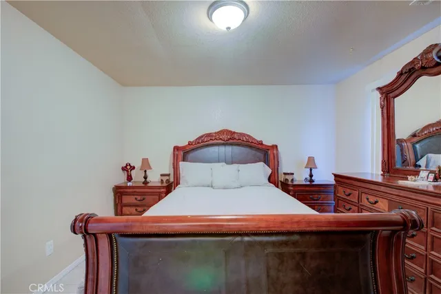 a room with a bed and a mirror on dresser