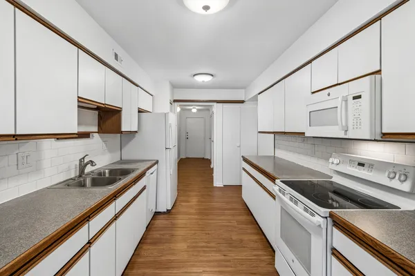 a kitchen with white cabinets sink and stainless steel appliances
