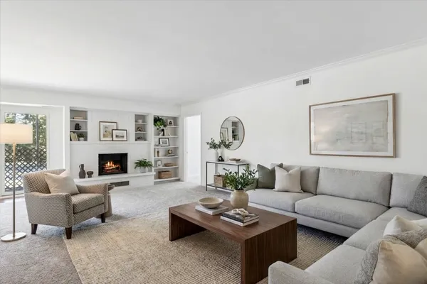 a living room with furniture a fireplace and a large window