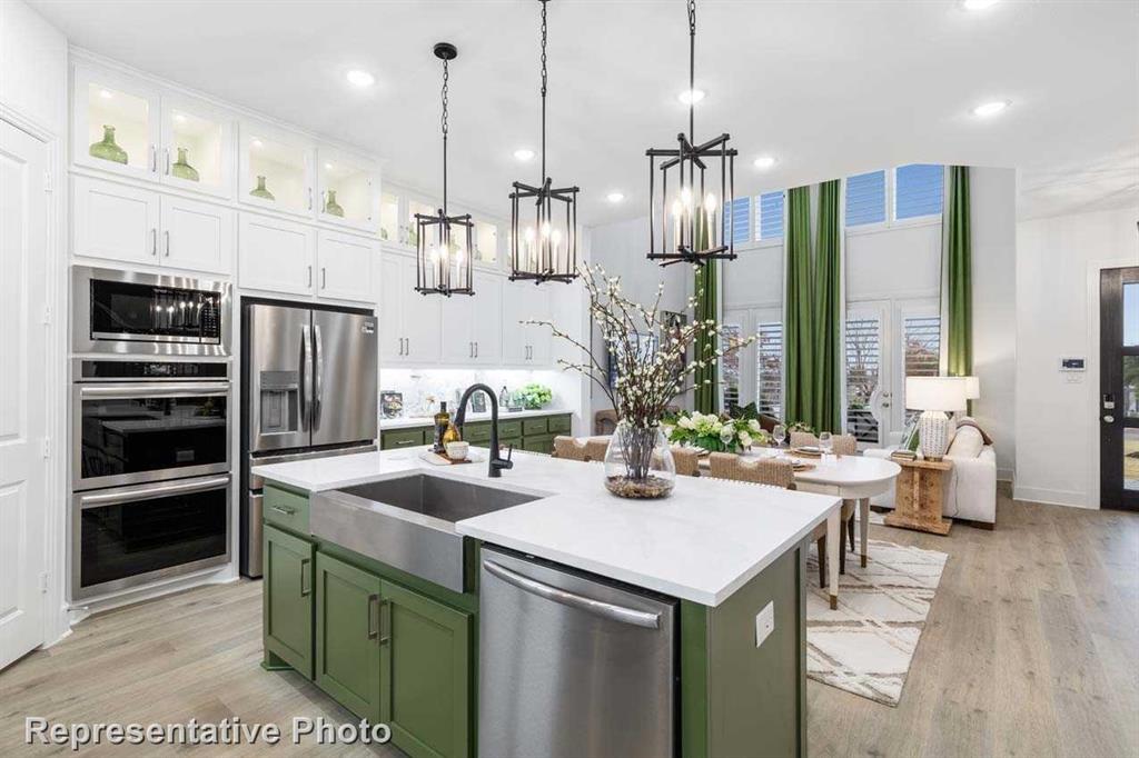 a kitchen with stainless steel appliances kitchen island granite countertop a sink and a refrigerator