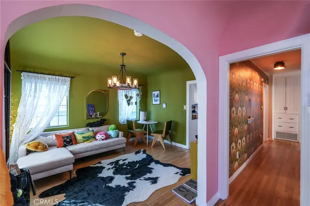 an empty room with wooden floor cabinet and windows