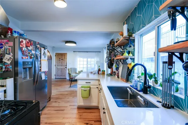 a view of hallway with window and wooden floor