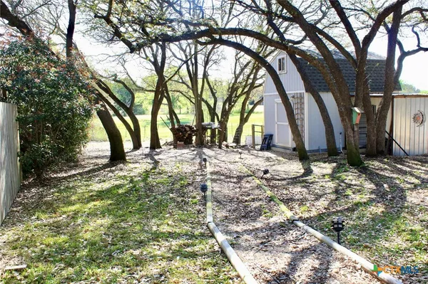 a view of a backyard with wooden fence
