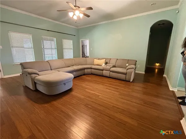 a living room with furniture and a wooden floor