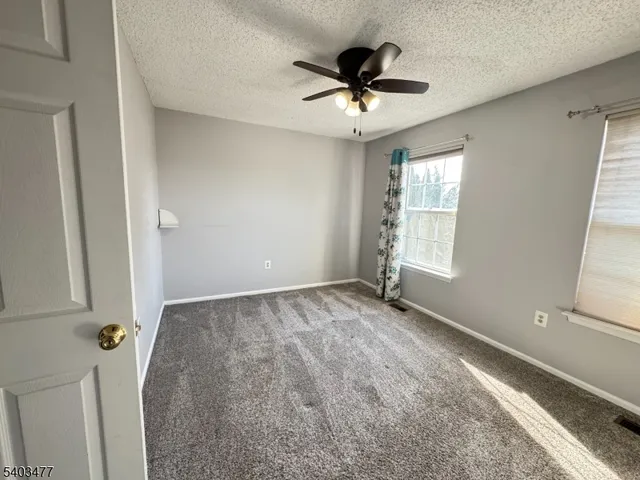 a view of empty room with ceiling fan
