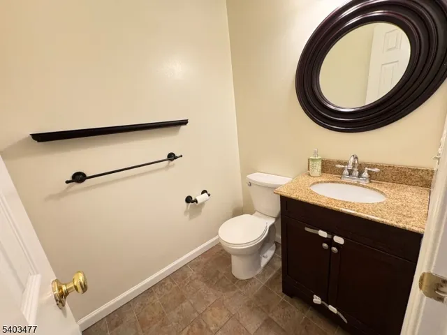 a bathroom with a granite countertop sink toilet and a mirror