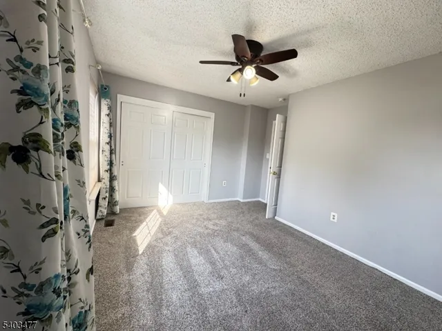 a view of a livingroom with a ceiling fan and window