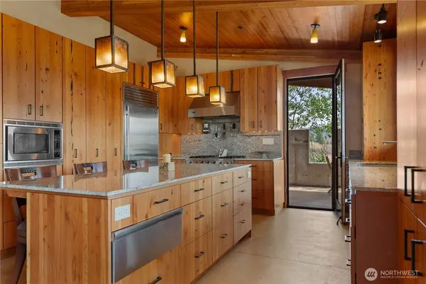 a kitchen with stainless steel appliances granite countertop a sink and a refrigerator