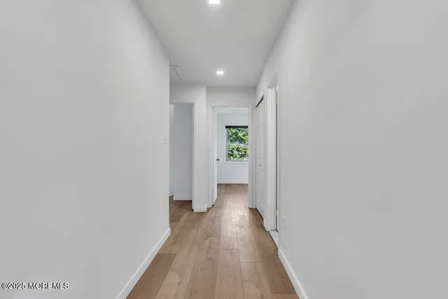 a view of a hallway with wooden floor