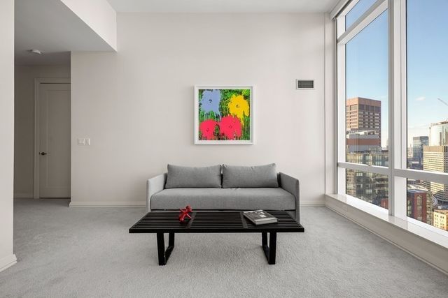 a living room with furniture a wall painting and a large window