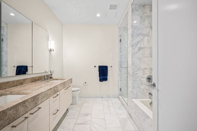 a spacious bathroom with a granite countertop sink a toilet and shower