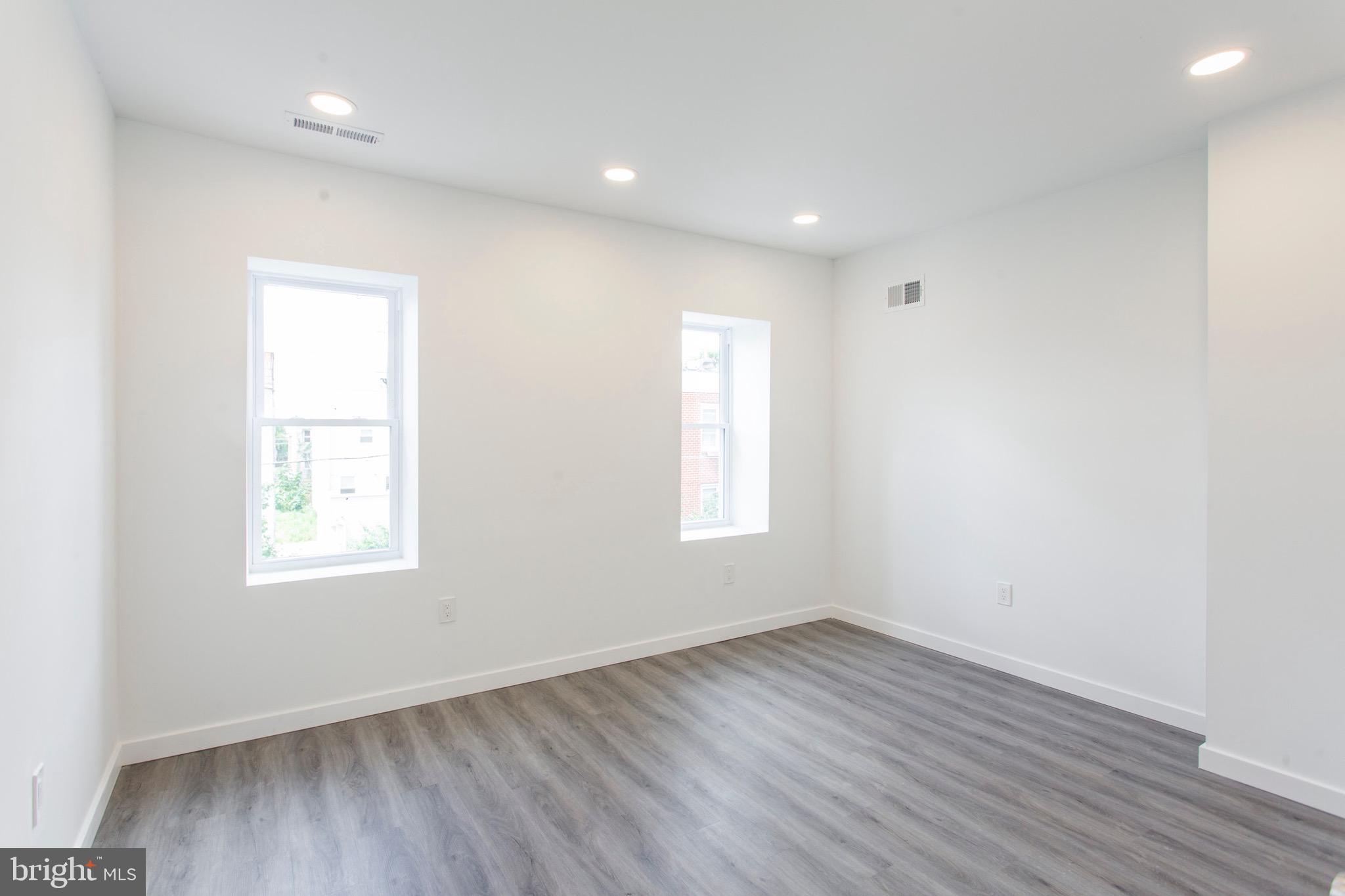 2131 North 8th Street, Unit 2 Philadelphia, PA 19122 - Photo 12 of 19 an empty room with wooden floor and windows