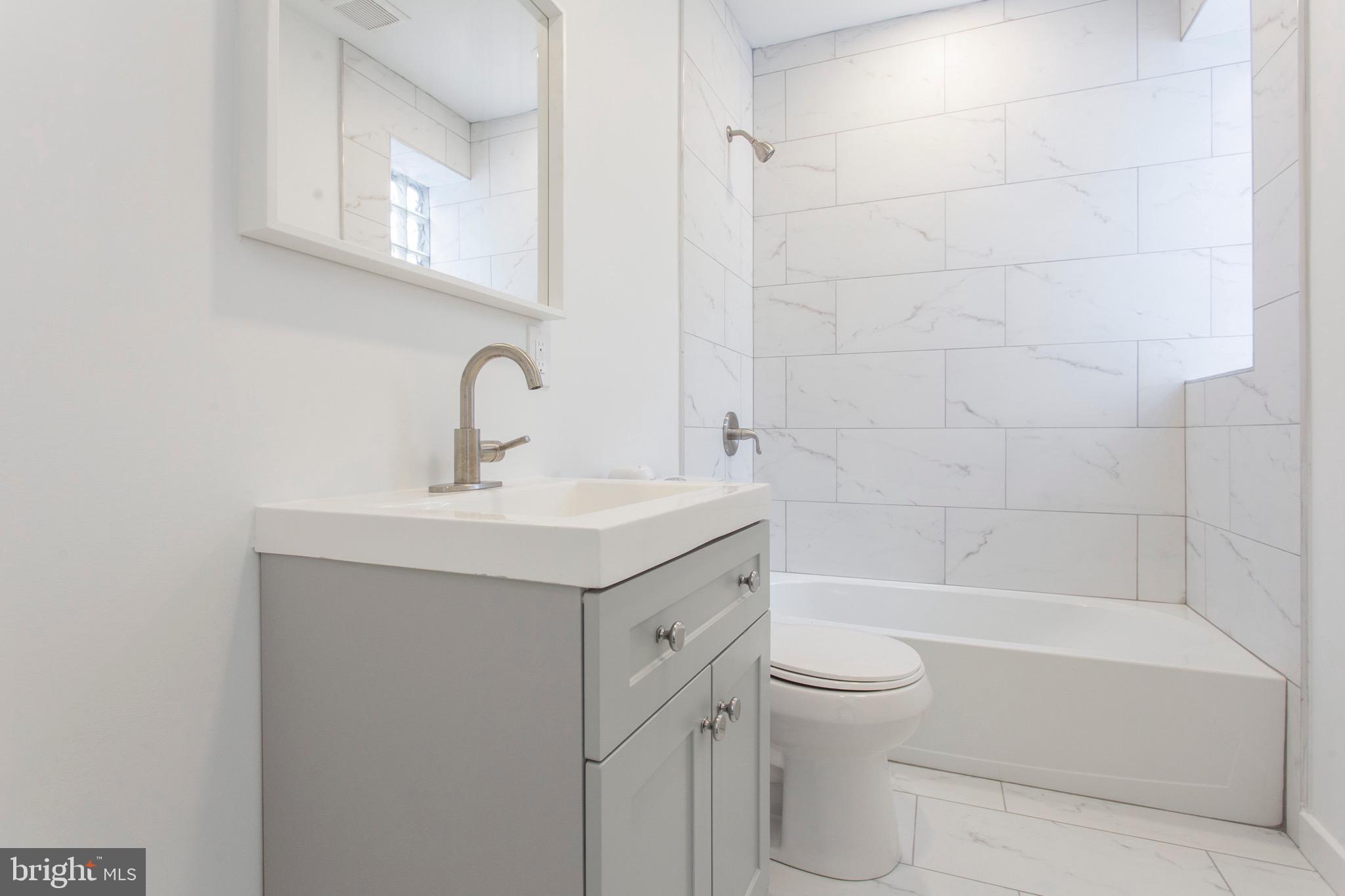2131 North 8th Street, Unit 2 Philadelphia, PA 19122 - Photo 17 of 19 a bathroom with a sink a toilet and shower
