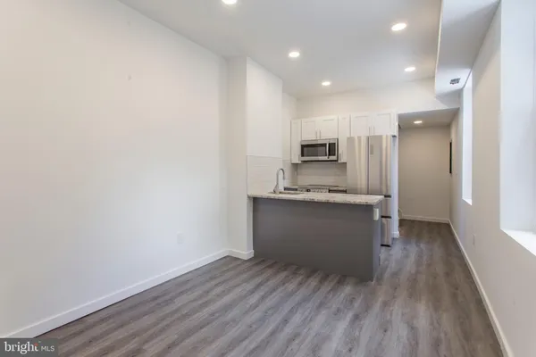a kitchen with a refrigerator and white cabinets