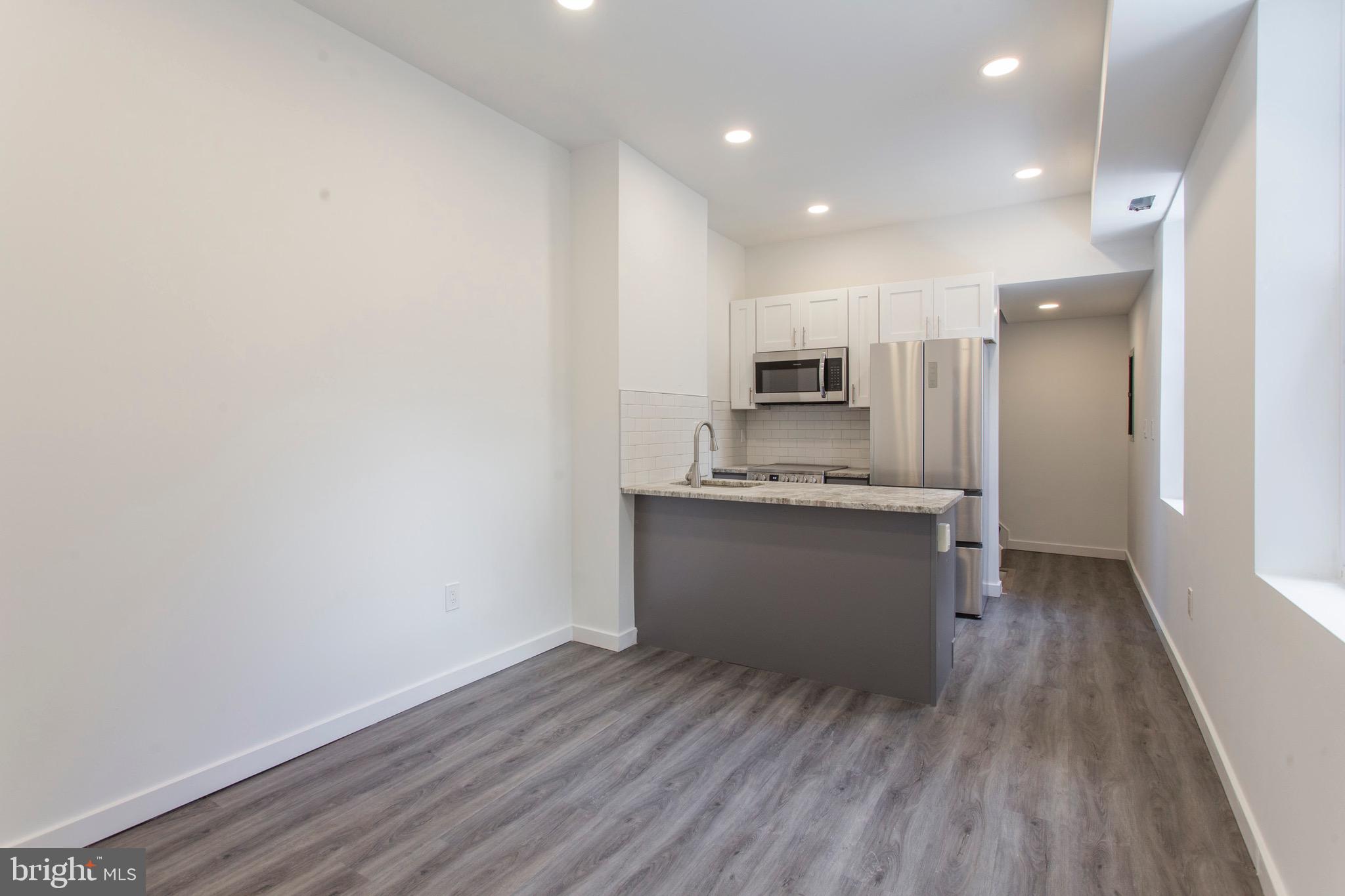 2131 North 8th Street, Unit 2 Philadelphia, PA 19122 - Photo 2 of 19 a kitchen with a refrigerator and white cabinets