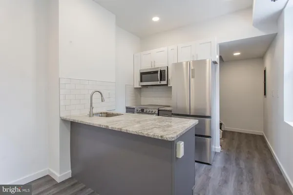 a kitchen with stainless steel appliances granite countertop a sink refrigerator and microwave