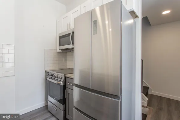 a kitchen with metallic refrigerator and microwave