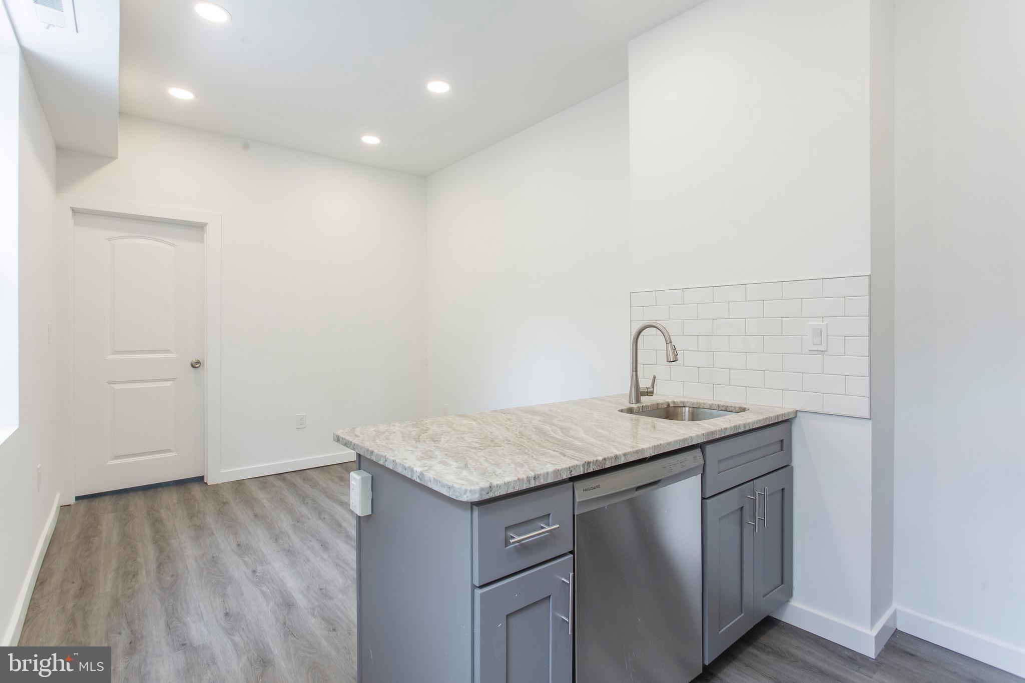 2131 North 8th Street, Unit 2 Philadelphia, PA 19122 - Photo 6 of 19 a bathroom with a granite countertop sink and vanity